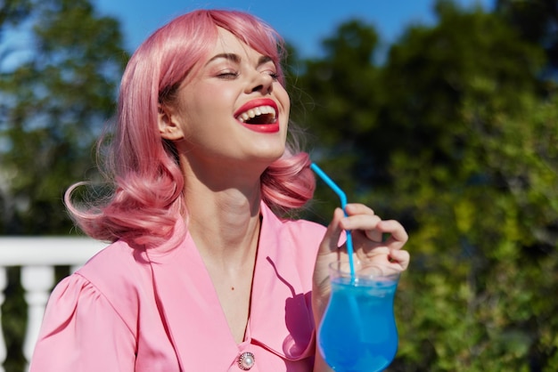 Mujer alegre con cabello rosado cóctel de verano bebida refrescante bebiendo alcohol foto de alta calidad