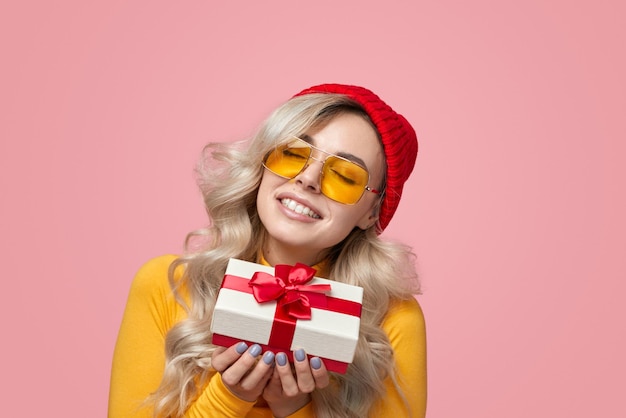 Mujer alegre con caja de regalo en estudio