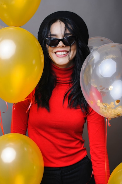 Mujer alegre cerca de globos sonriendo