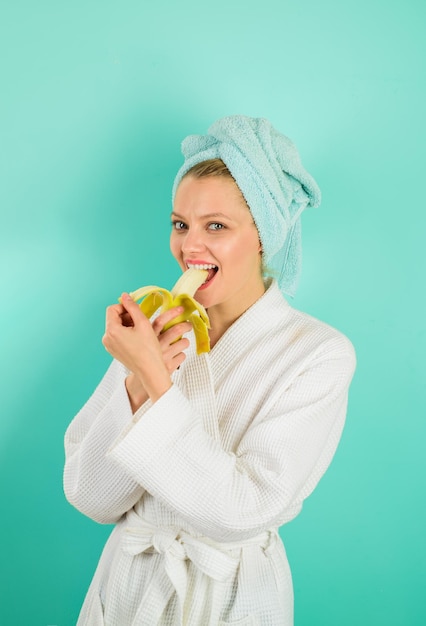 Mujer alegre comer delicioso desayuno de plátano a mujer en casa estilo de vida saludable alimentación saludable tropical