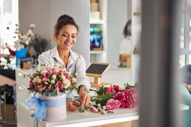 Mujer alegre disfrutando de ser un florista calificado