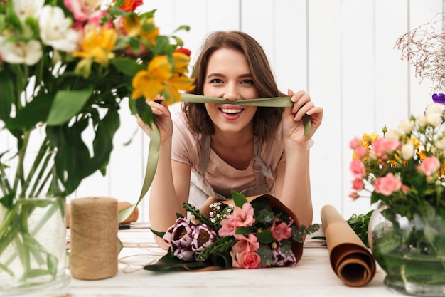 Mujer alegre Floreria con flores en el taller