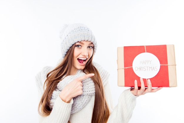 Mujer alegre en gorro y bufanda con paquete y felicitar con Navidad