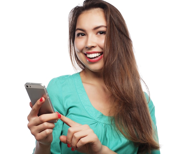 Mujer alegre hablando por teléfono aislado sobre un fondo blanco.