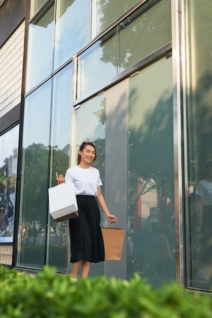 Mujer alegre haciendo compras en una gran ciudad