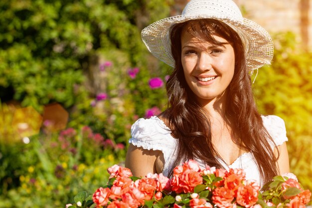 Mujer alegre en jardín de flores de verano