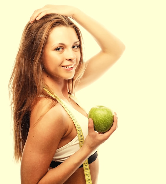 Mujer alegre joven en ropa deportiva con manzana