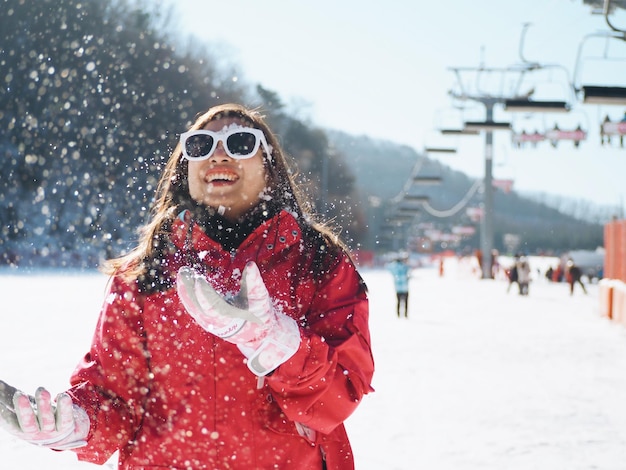 Foto mujer alegre jugando con la nieve en el campo