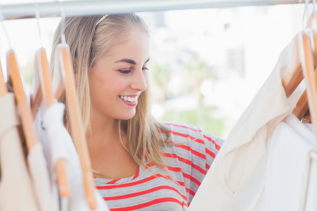 Mujer alegre mirando ropa