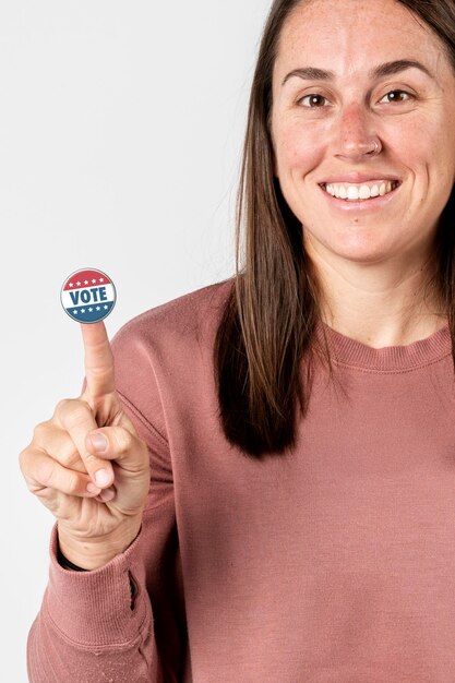 Mujer alegre con una pegatina de voto en su dedo índice