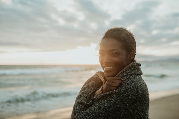 Mujer alegre en la playa en una fría noche de verano