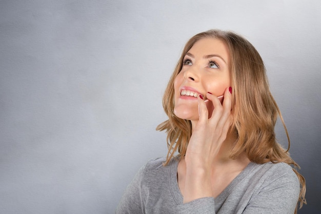 Mujer alegre que habla en el teléfono aislado