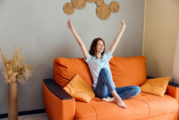 Foto mujer alegre en el sofá descanso divertido apartamentos comfort