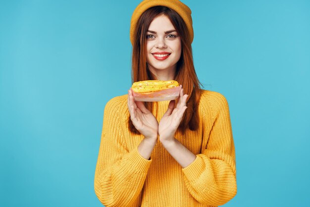 Mujer alegre con taza de bebida caliente y cupcake en manos estilo de vida de desayuno Foto de alta calidad
