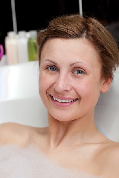 Mujer alegre tomando un baño en un spa