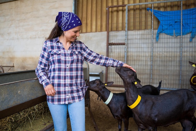 mujer alimentando a las cabras en una antigua granja