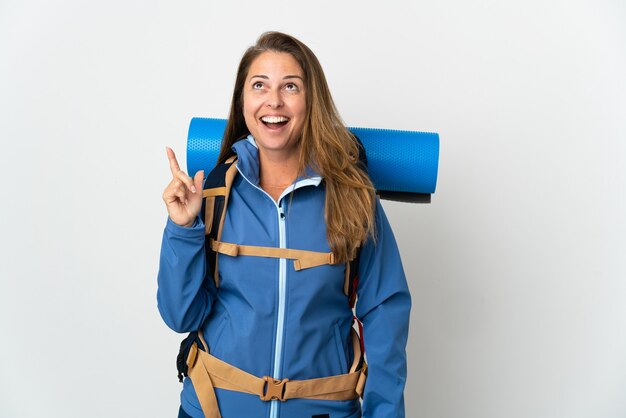 Mujer alpinista de mediana edad con una mochila grande sobre pensamiento aislado una idea apuntando con el dedo hacia arriba