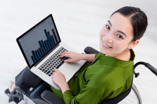 Foto mujer de alto ángulo que trabaja en la computadora portátil