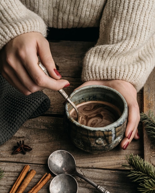 Mujer de alto ángulo sosteniendo la taza con chocolate caliente