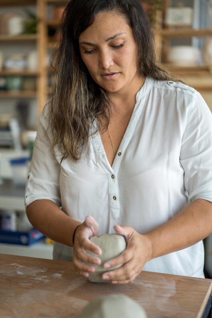 Foto una mujer amasa arcilla para hacer cerámica