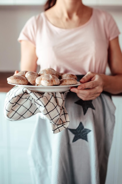 Mujer amasa la masa. Coockies de jengibre en mesa de madera. Cocina casera acogedora. Hornear en casa.