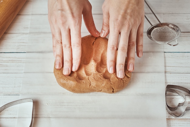 Mujer amasa la masa con las manos en la cocina