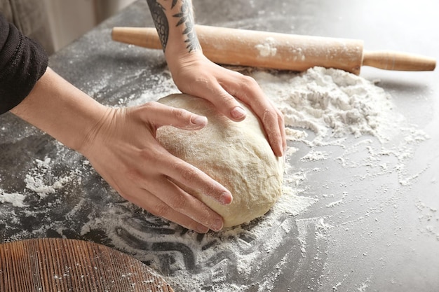 Mujer amasando la masa en la mesa de la cocina