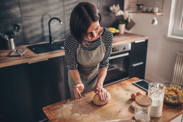 Mujer amasar sobre la mesa de madera