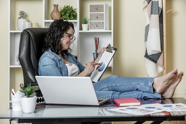 Foto mujer analizando gráficos en la oficina en casa