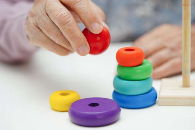 Foto mujer anciana asiática jugando un juego de rompecabezas para el tratamiento, la prevención de la demencia y la enfermedad de alzheimer