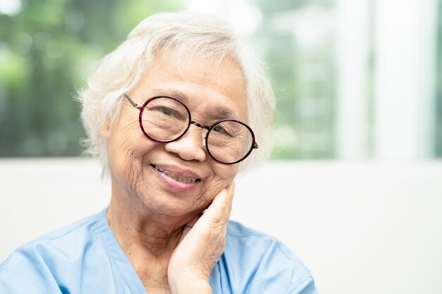 Foto mujer anciana asiática que usa gafas o gafas de visión en el servicio de atención domiciliaria