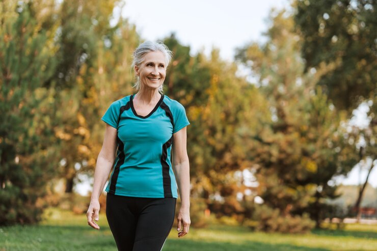 Mujer anciana caminando en el parque disfrutando de mirar hacia otro lado copia el espacio concepto de estilo de vida saludable