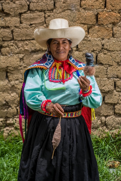 Mujer andina latinoamericana teñir lana de oveja con productos naturales ancestrales peruanos