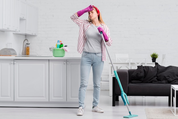 Mujer de ángulo bajo cansada de la limpieza