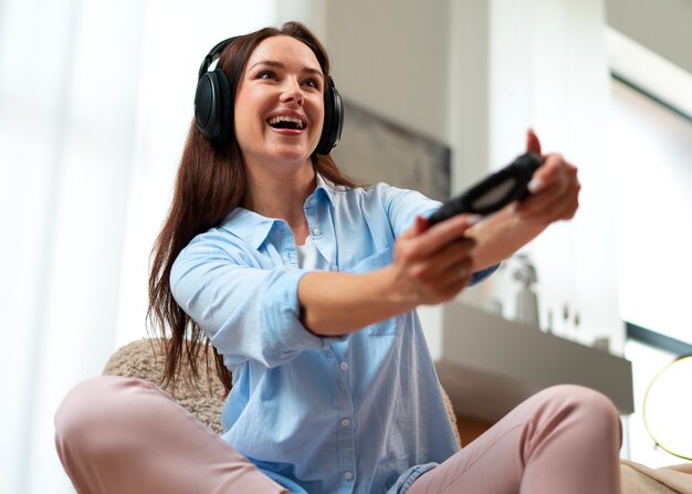 Foto mujer de ángulo bajo jugando videojuegos