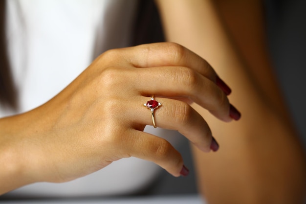 Una mujer con un anillo con una piedra roja.