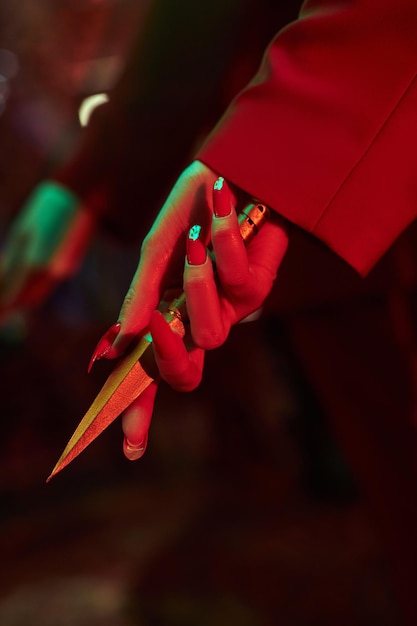 Mujer de anime con un traje rojo con corte de pelo corto, cabello negro. Una chica asesina con una chaqueta roja y una daga en la mano. Retrato de belleza