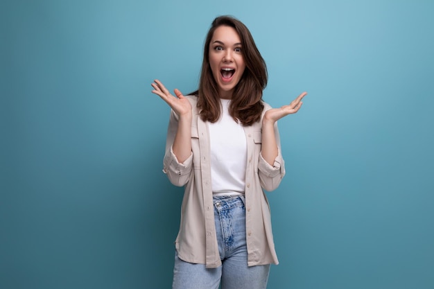 Mujer de un año sorprendida con un aspecto elegante pensando en un fondo azul