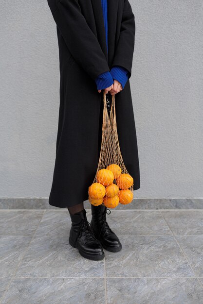 Mujer anónima sosteniendo naranjas frescas