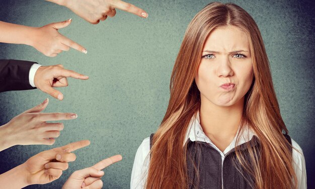 Mujer ansiosa juzgada por diferentes manos. Concepto de acusación de culpable.