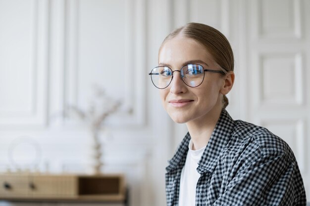Una mujer con anteojos es una economista independiente que trabaja, usa una computadora portátil y hace un informe