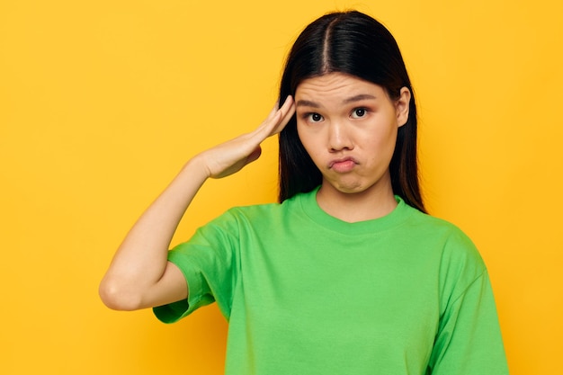 Mujer con apariencia asiática posando en camiseta verde emociones copyspace Estilo de vida inalterado