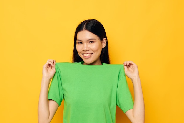 Mujer con apariencia asiática posando en camiseta verde emociones copyspace Estilo de vida inalterado