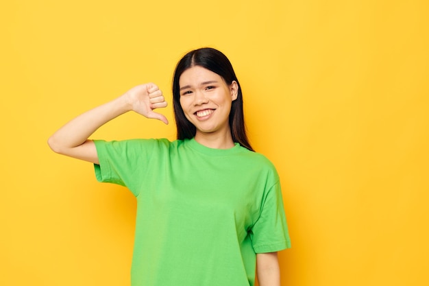 Mujer con apariencia asiática posando en camiseta verde emociones copyspace fondo aislado inalterado