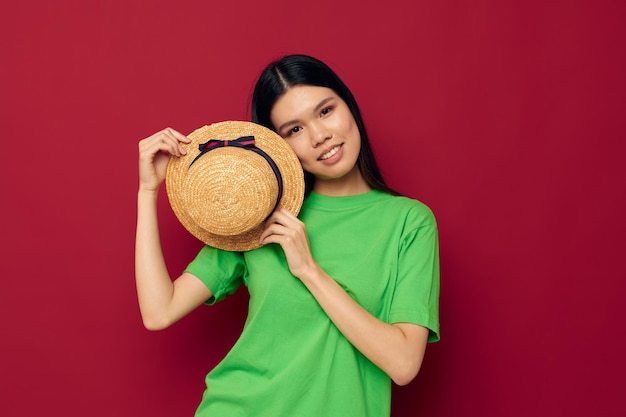 Mujer con apariencia asiática sonrisa camiseta verde sombrero posando moda fondo aislado inalterado