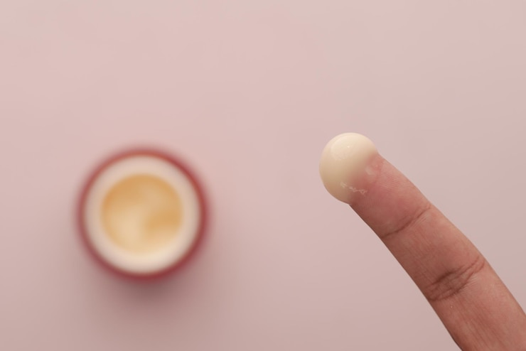 Foto mujer aplicando crema de belleza sobre la piel en la vista superior de casa