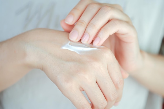 Mujer aplicando crema hidratante para manos Concepto de cuidado de la salud de la mano