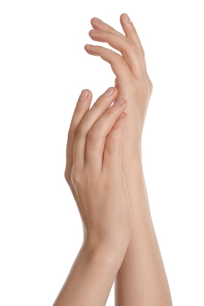 Mujer aplicando crema en la mano contra el primer plano de fondo blanco