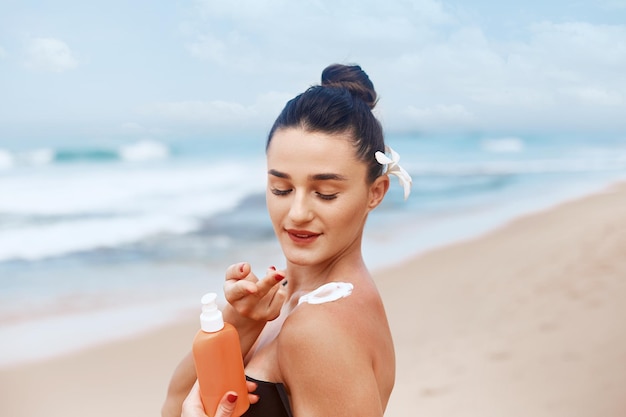 Mujer aplicando crema solar en el hombro Cuidado de la piel Cuerpo Protección solar Protector solar