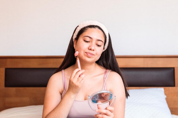 Una mujer aplicando un espejo en su rostro.